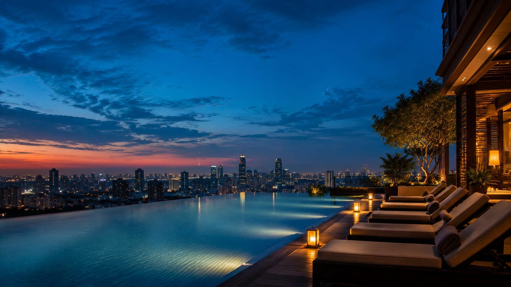 Luxury hotel infinity pool overlooking a city skyline at dusk